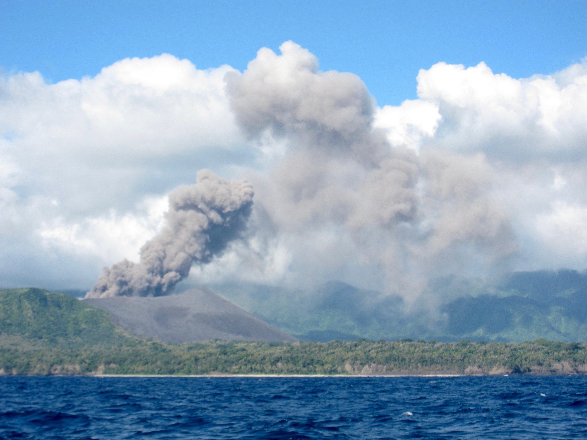 Ash from the volcano falls like snow on the boat